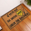 Softball doormat displayed in an entryway on a wood floor beside a white door