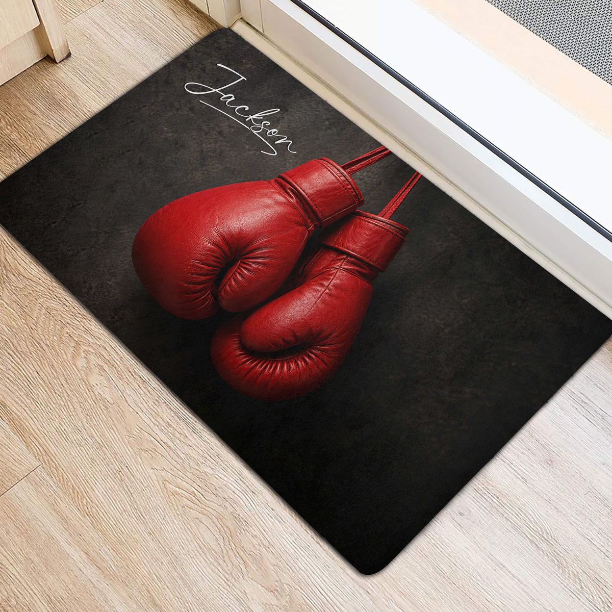 Red boxing glove design displayed on a dark doormat beside an interior doorway