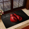 Boxing glove entryway mat presented near a glass door and indoor floral decor