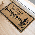 Wine bottle and grape doormat styled at an indoor doorway with wood flooring