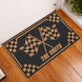 Checkered flag motocross doormat styled at a home entryway beside a white door and wood floor