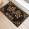 Black and gold motocross racing flag doormat displayed near a doorway on a light wood floor