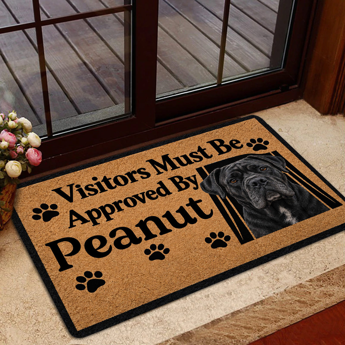 Cane Corso doormat displayed inside a glass doorway with bold black lettering and a dog portrait