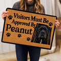 Cane Corso doormat held indoors, showing the tan and black design, paw prints, and realistic dog portrait