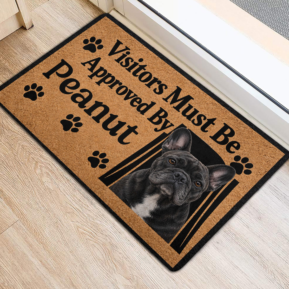 French Bulldog welcome mat positioned at an indoor entrance with paw print accents