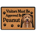 Goldendoodle doormat with a curly dog portrait, paw prints, and playful visitor message in tan and black