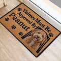 Goldendoodle door mat in a home entrance featuring a curly dog portrait, paw prints, and bold black lettering