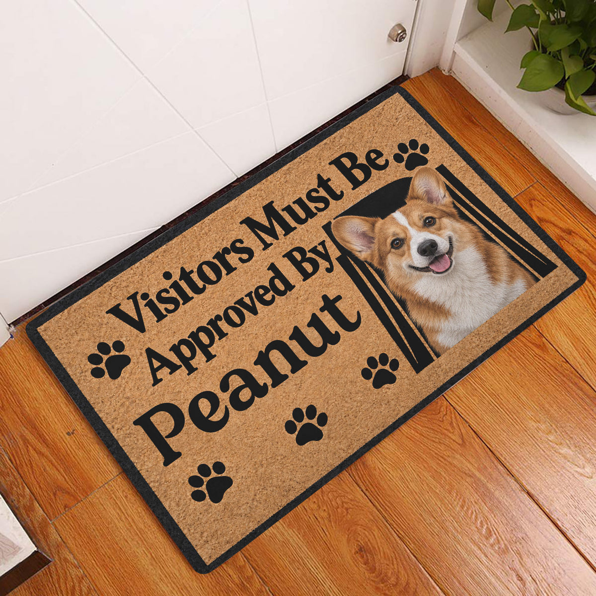 Corgi entryway doormat displayed on a wood floor beside a white door with a smiling dog portrait
