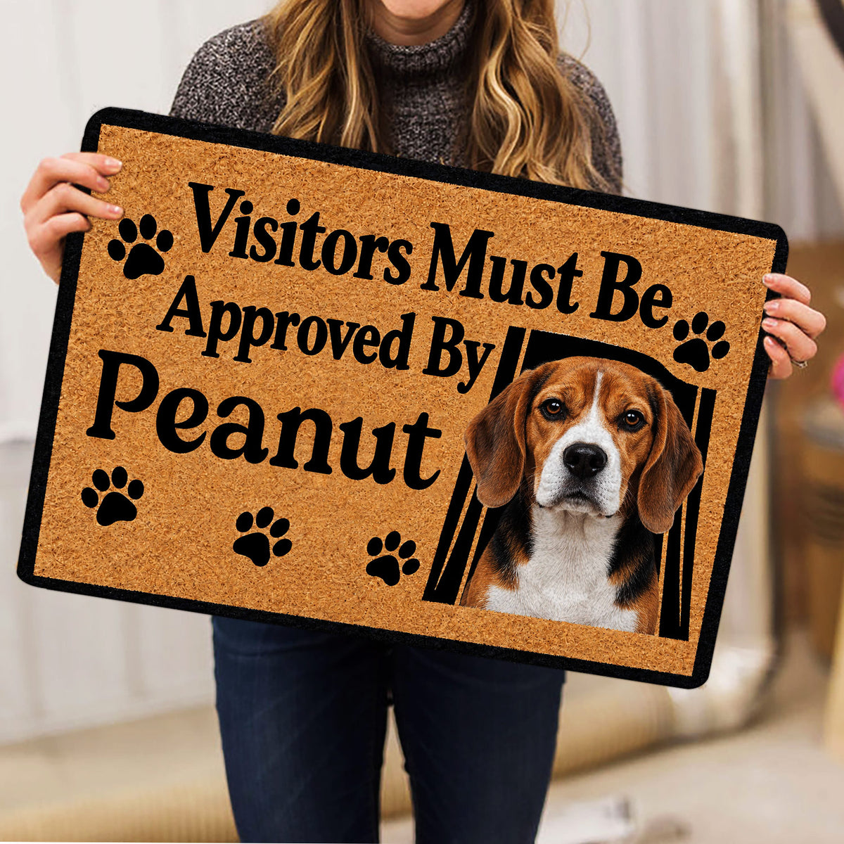 Person holding a Beagle doormat featuring paw prints, a dog portrait, and a welcoming design