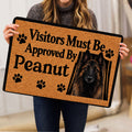 Person holding a Belgian Shepherd doormat featuring a black-and-tan shepherd portrait and paw print artwork