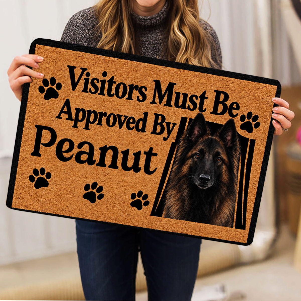 Person holding a Belgian Shepherd doormat featuring a black-and-tan shepherd portrait and paw print artwork