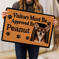 Person holding a Chihuahua doormat featuring paw prints and a framed dog portrait