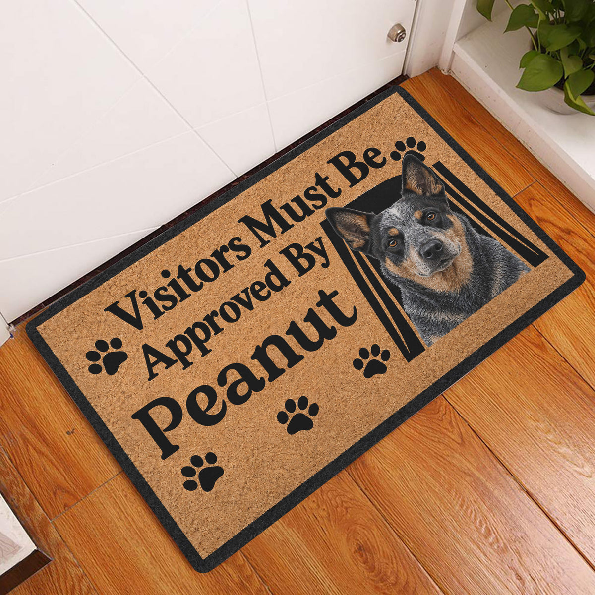 Australian Cattle Dog entryway doormat displayed on a warm wood floor beside a white door