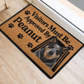 Australian Cattle Dog doormat placed by a doorway, featuring a detailed dog portrait, paw prints, and bold lettering