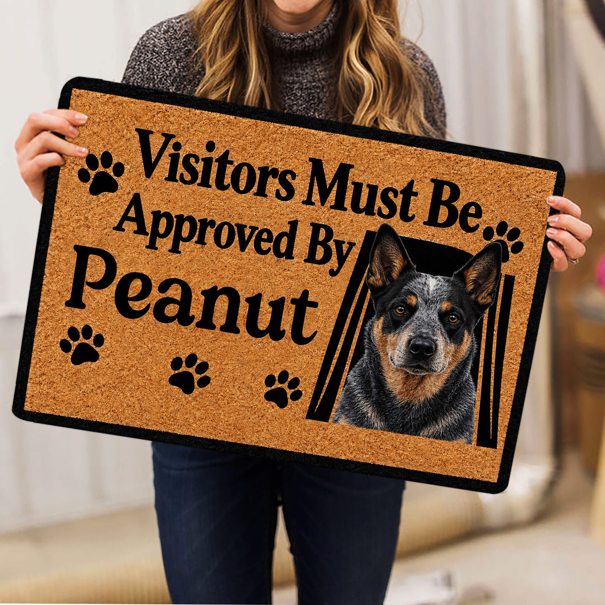 Australian Cattle Dog doormat held indoors, showing tan and black artwork, paw prints, and a detailed dog portrait