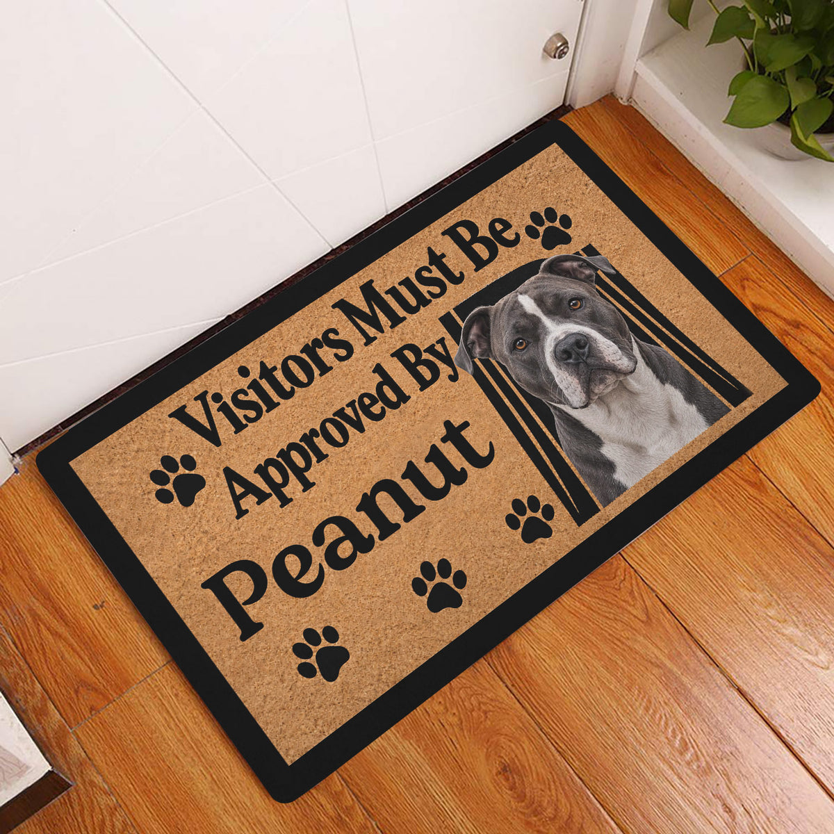 American Staffordshire dog doormat displayed in a home entryway on a warm wood floor