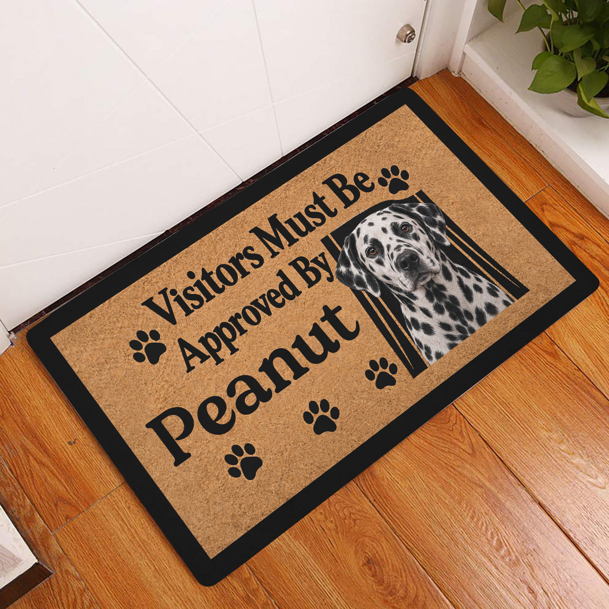 Dalmatian entryway doormat displayed on a wood floor beside a white door