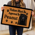 Curly Coated Retriever doormat held indoors, showing the black dog portrait and paw print artwork