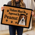 Person holding a Jack Russell doormat featuring a terrier portrait, paw prints, and bold black lettering