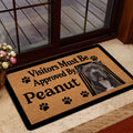 Pitbull doormat styled inside a glass doorway, featuring a tan background, black border, paw prints, and dog artwork