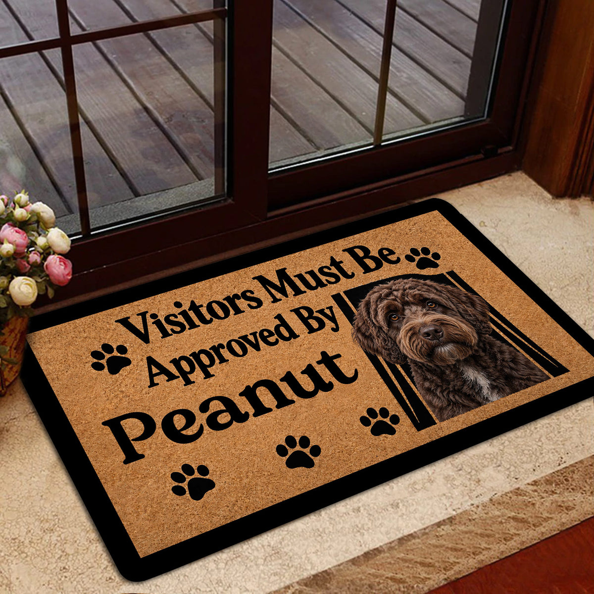 Labradoodle entryway rug styled inside a glass door with a tan background and black border