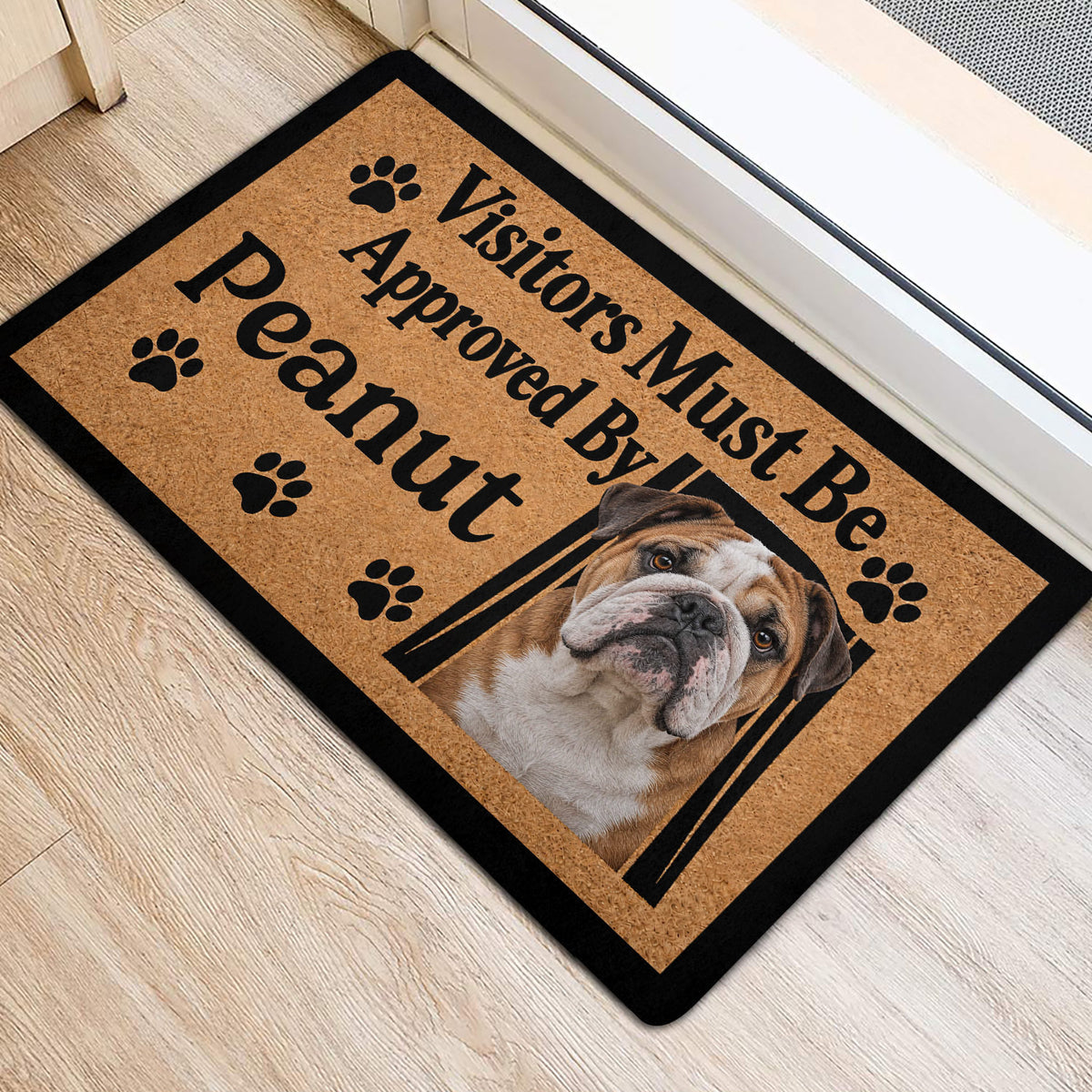 English Bulldog front door mat with paw prints and bold black lettering on a light wood floor