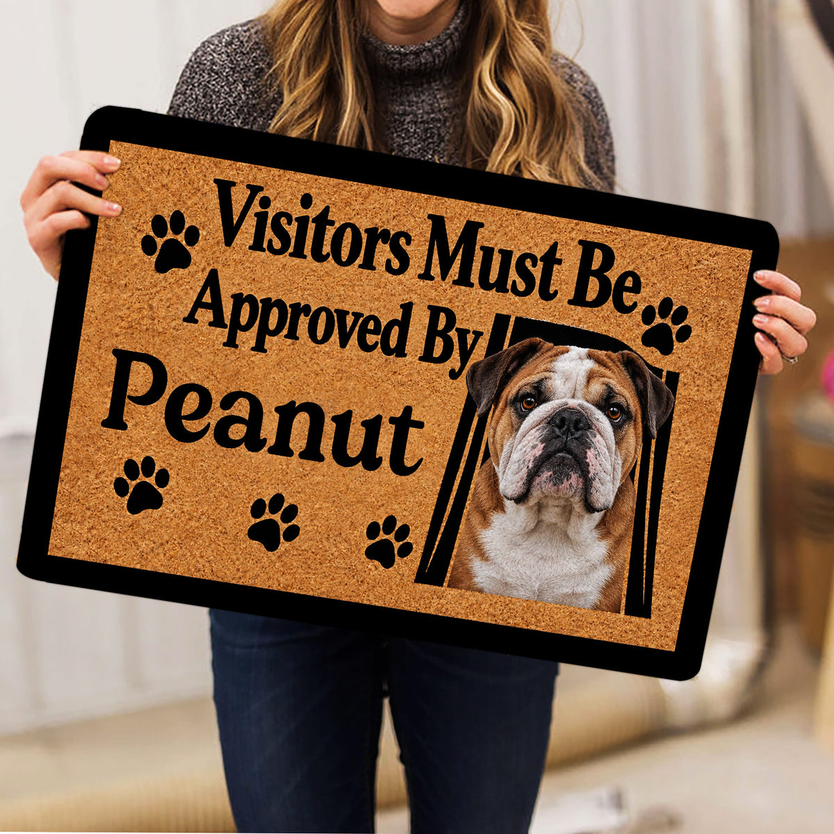 English Bulldog doormat held indoors, showing the full brown paw print design and black border