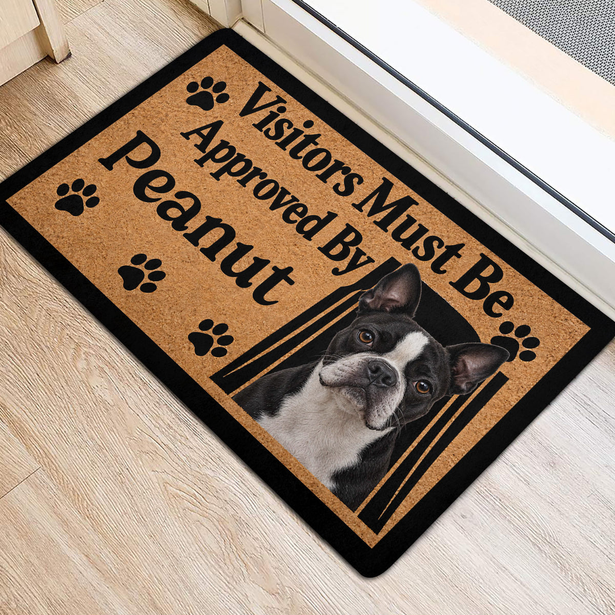 Boston Terrier entryway rug beside a door, featuring paw prints and a framed dog portrait