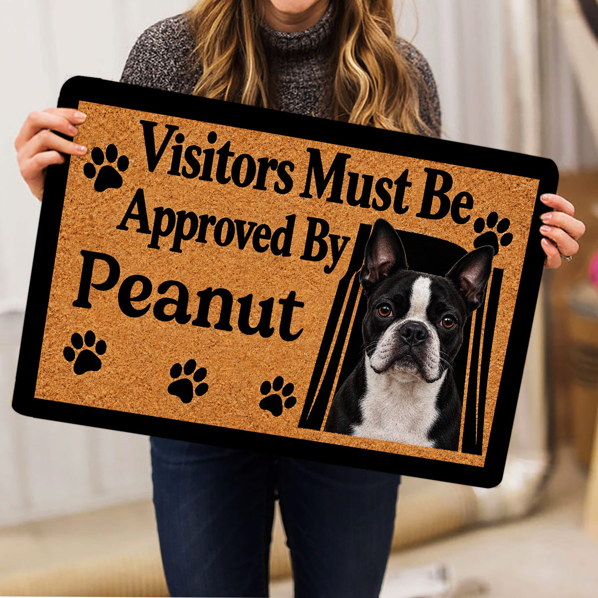 Boston Terrier doormat held indoors, showing the tan and black design with paw prints and dog portrait