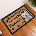 Westie doormat styled in an indoor entryway beside a white door and wooden flooring