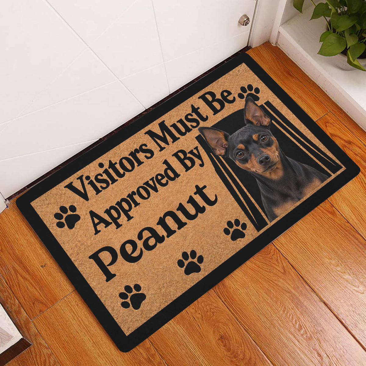 Miniature Pinscher doormat displayed by a white entry door on a warm wood floor