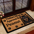 Miniature Pinscher doormat styled inside a glass doorway with a warm home entry setting