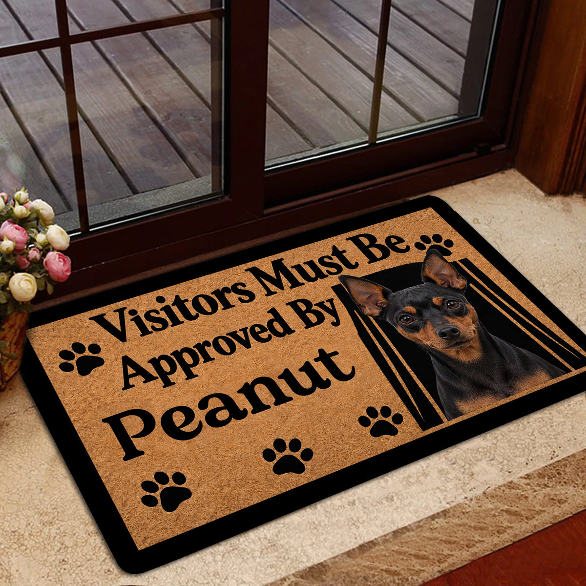 Miniature Pinscher doormat styled inside a glass doorway with a warm home entry setting