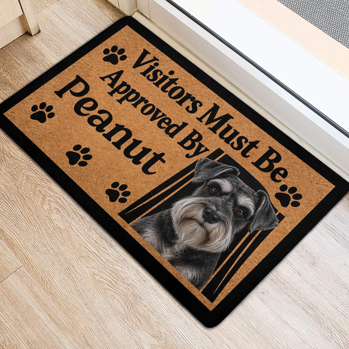 Miniature Schnauzer door mat shown at a home entrance with a tan paw print design and black border