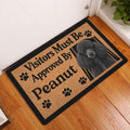 Poodle welcome doormat displayed in an entryway beside a white door and wood flooring