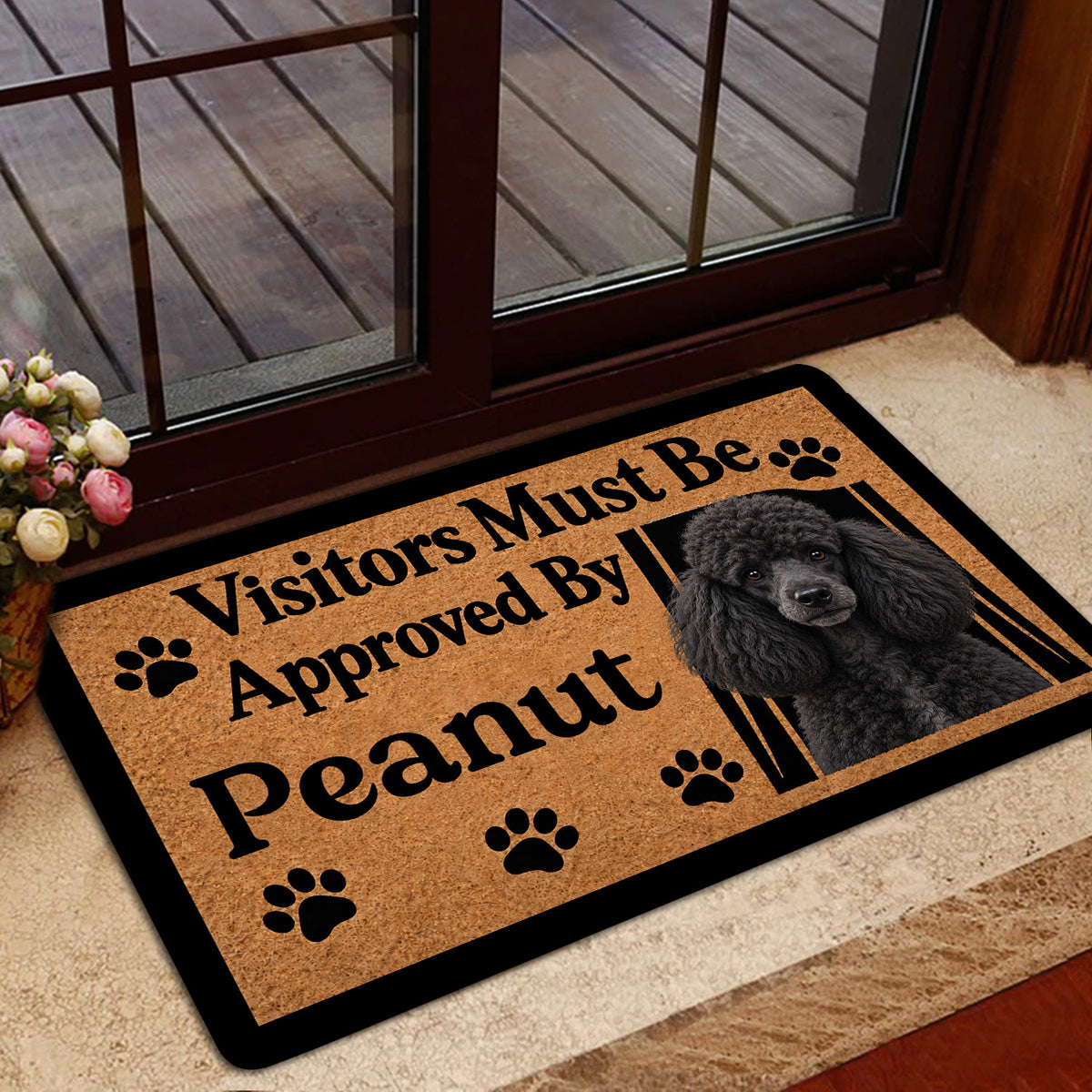 Poodle welcome mat shown at a home entrance with a glass door, flowers, and warm interior decor