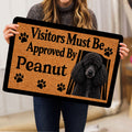 Person holding a poodle doormat featuring a black curly dog portrait, paw prints, and tan artwork