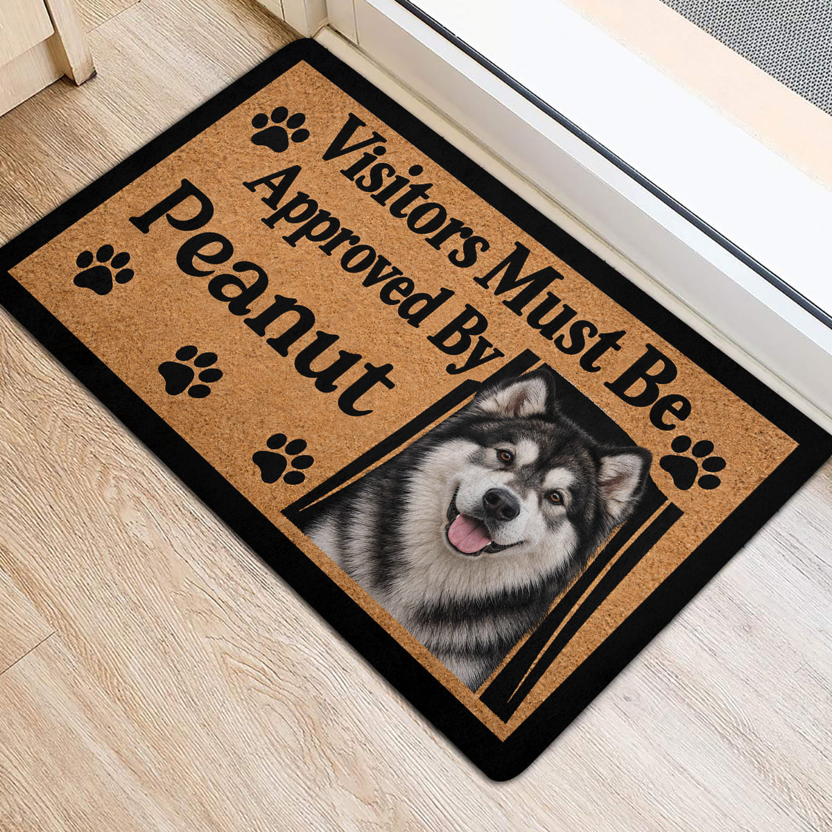 Alaskan Malamute front door mat with paw prints and a tan, black, and white dog portrait design