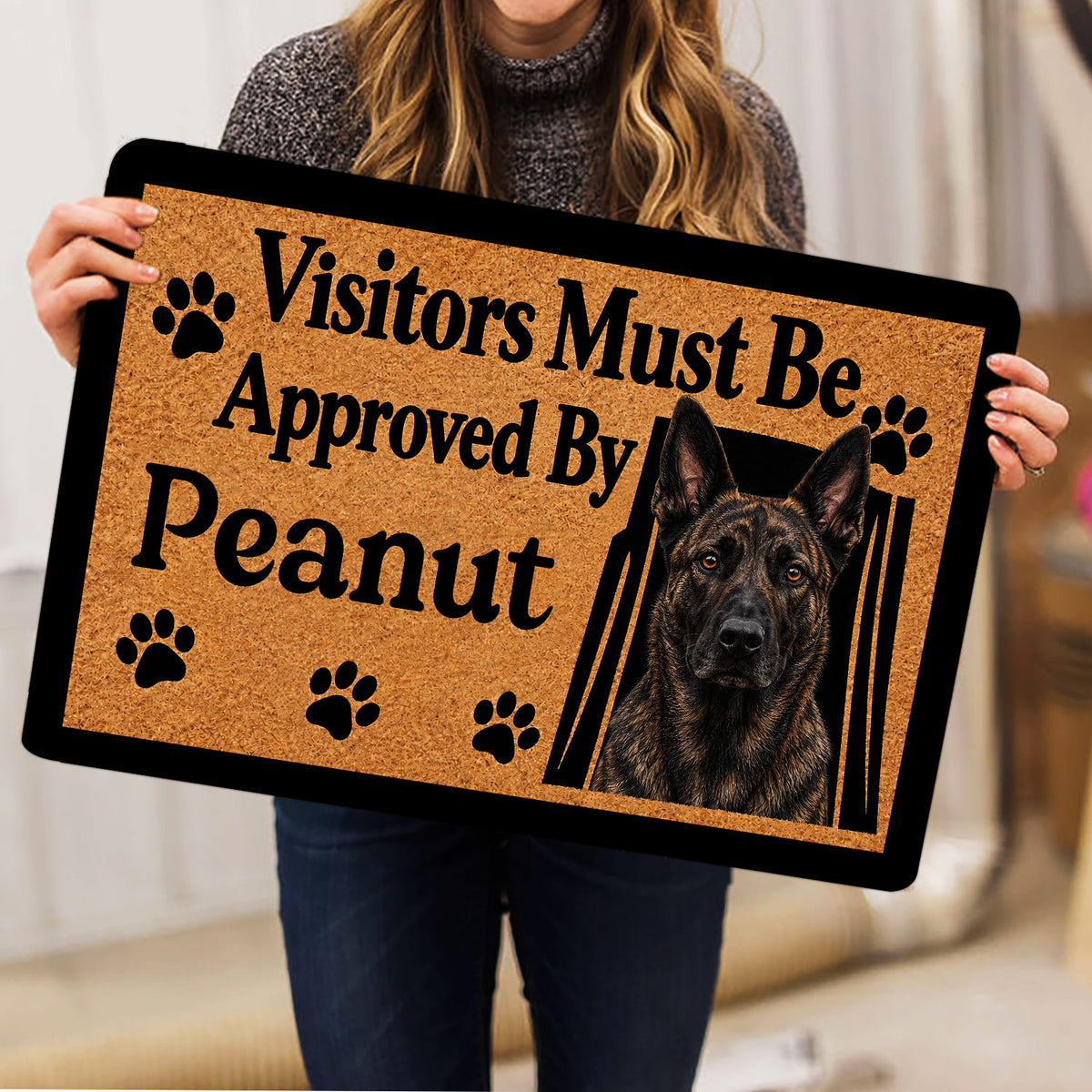 Person holding a Dutch Shepherd doormat featuring a realistic portrait and playful paw-print design