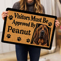 Person holding a bloodhound doormat featuring a realistic portrait and paw print design