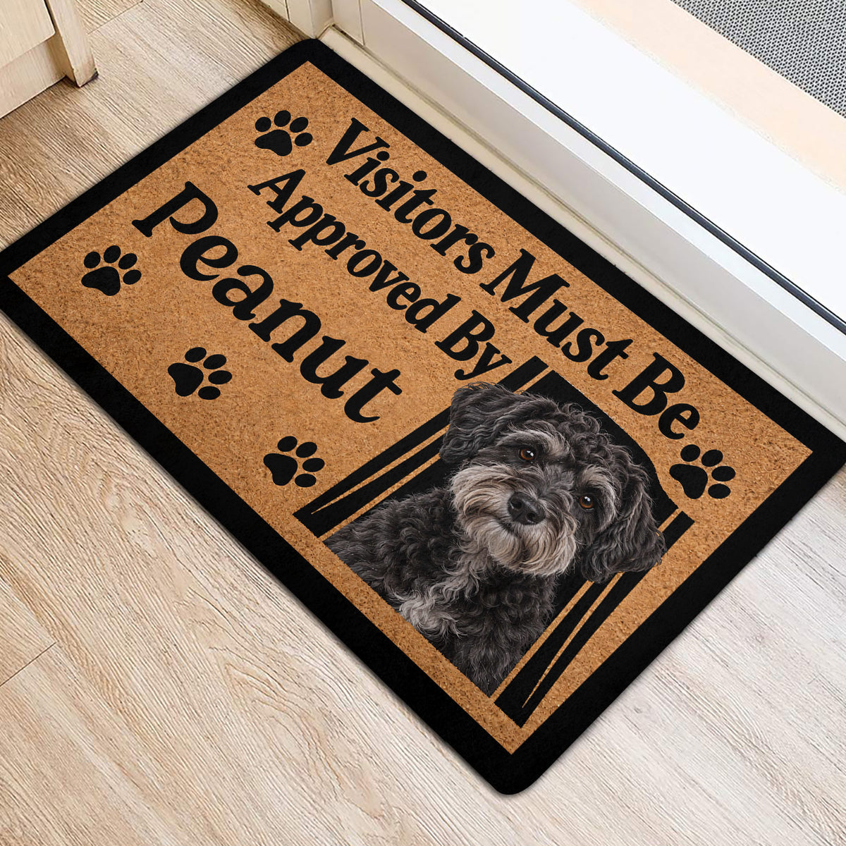 Schnoodle portrait entryway mat with paw prints beside a doorway