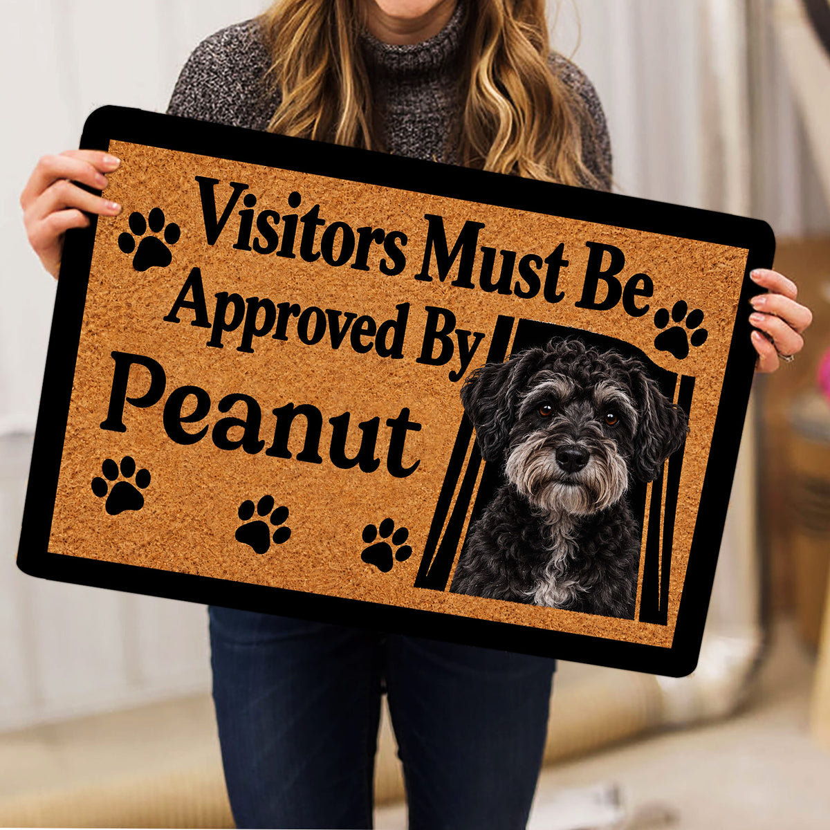 Person holding a Schnoodle dog doormat featuring a portrait and paw prints