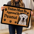 Person holding a Dogo Argentino doormat featuring a white dog portrait and black paw prints