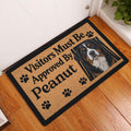 Bernese Mountain Dog entryway doormat displayed on a warm wood floor beside a white door