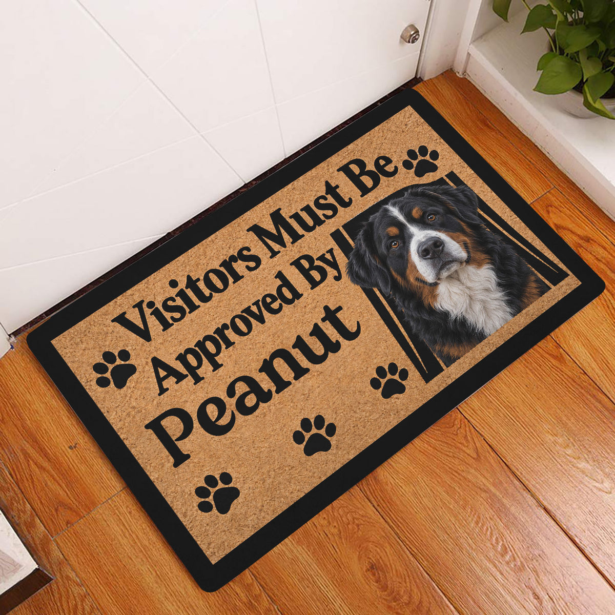 Bernese Mountain Dog entryway doormat displayed on a warm wood floor beside a white door