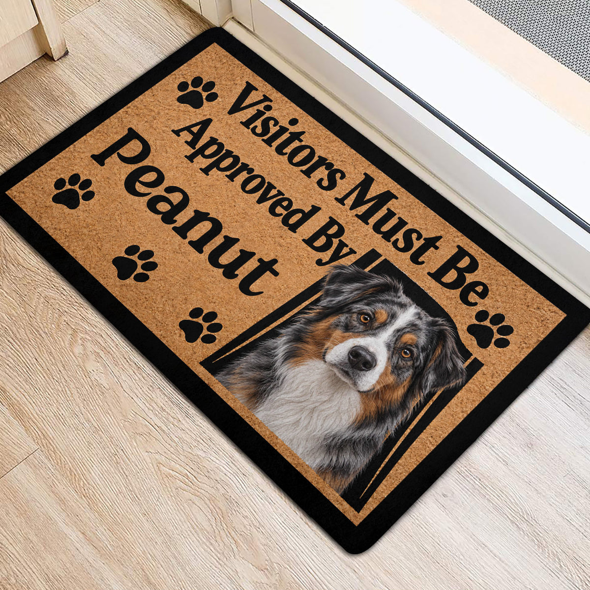Australian Shepherd entryway mat beside a doorway with paw prints and bold black lettering