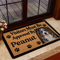 Australian Shepherd doormat styled near a glass door with tan artwork, paw prints, and black border