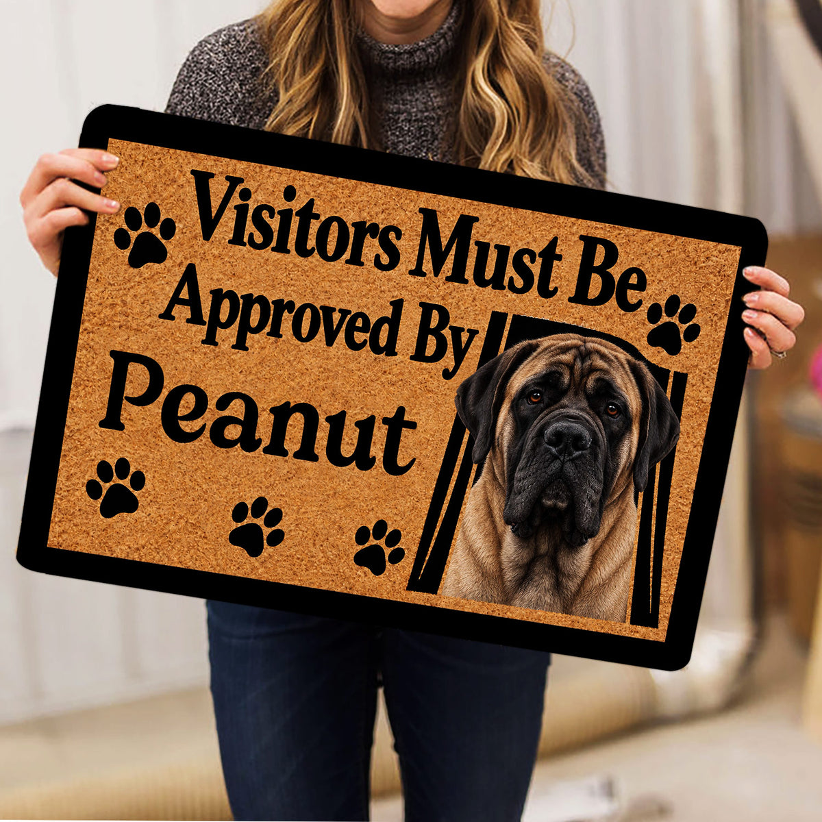 English Mastiff doormat held indoors, showing the realistic dog portrait, paw prints and tan artwork