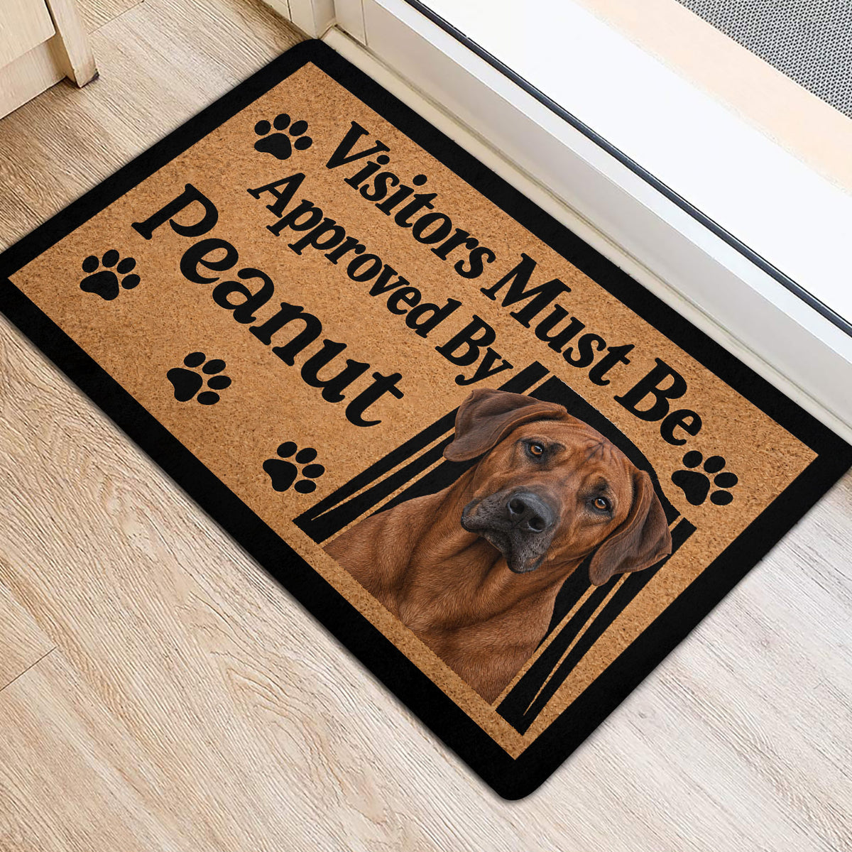 Dog-themed entryway mat featuring a Rhodesian Ridgeback portrait and black paw print accents