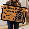 Person holding a Cairn Terrier doormat featuring a dog portrait and paw print accents